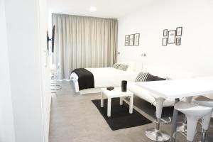 - une chambre blanche avec un lit et un bureau dans l'établissement Black & White Las Canteras, à Las Palmas de Gran Canaria