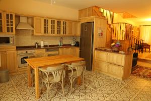 eine Küche mit einem Holztisch und einem schwarzen Kühlschrank in der Unterkunft Villa Emel in Antalya