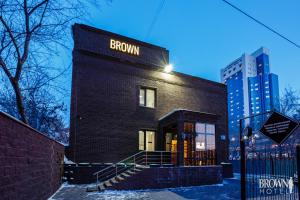 a black brick building with a brown sign on it at Brown Hotel in Astana