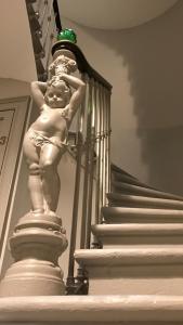 a statue of a man standing on a stair case at 7 Hotel Particulier in Agen