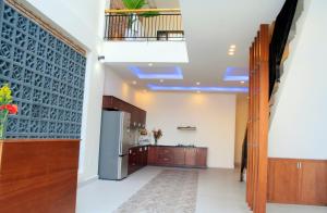 a kitchen with wooden cabinets and a stainless steel refrigerator at Melody Boutique Villa Hoi An in Hoi An