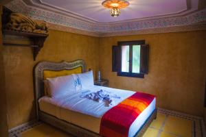a bedroom with a bed with a colorful blanket at Targa Imoula in Imlil