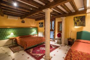 a bedroom with a bed and a green headboard at Sant'Angelo - Fenice Apartments in Venice in Venice