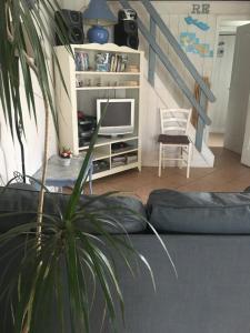 a living room with a couch and a stair case at La Petite Maison sur l'Ile de Ré in La Flotte
