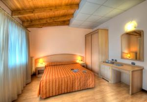 1 dormitorio con 1 cama, 2 mesas y espejo en Hotel Residence Dei Fiori, en Baveno