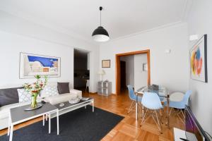 ein Wohnzimmer mit einem Sofa und einem Tisch in der Unterkunft Athens Squared Apartments in Athen