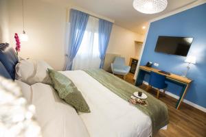 una camera con letto, scrivania e TV di La Gustea Hotel & Cucina a Sarteano