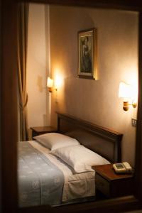 una camera con un letto e due tavoli e una foto di Hotel Giardino a Follonica