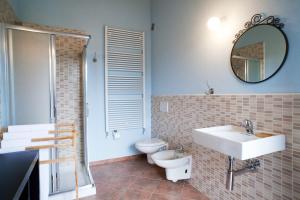 a bathroom with a sink and a toilet and a mirror at Affittacamere Il Torchio in Pianfei