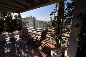 a balcony with a bench and potted plants at Athens Squared Apartments in Athens