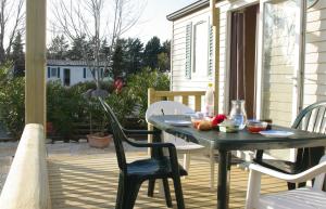 een patio met een tafel en stoelen op een veranda bij Camping Ensoya in Sigean