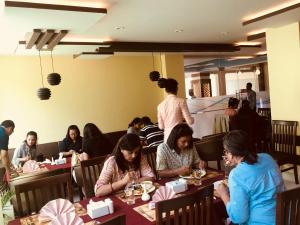 a group of people sitting at tables in a restaurant at Kaveri Inn in Kathmandu