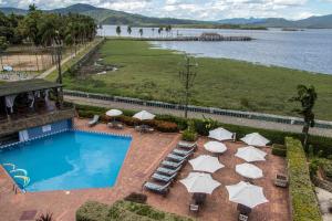 an image of a pool with umbrellas and chairs at Hotel Camboa Antonina - PR in Antonina