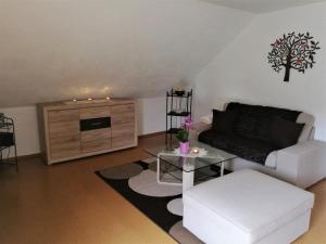 a living room with a white couch and a table at Ferienwohnung Edda in Ebensfeld