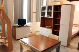 uma sala de estar com uma mesa e uma televisão num quarto em Residence Villa Marina em Marina di Ravenna