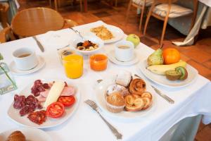 a table with plates of breakfast foods and cups of coffee at Tuc Blanc in Baqueira-Beret