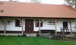 una pequeña casa blanca con techo rojo en Rigó Vendégház en Őriszentpéter