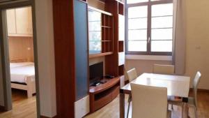 a living room with a table and a tv and a bedroom at Residence Villa Marina in Marina di Ravenna