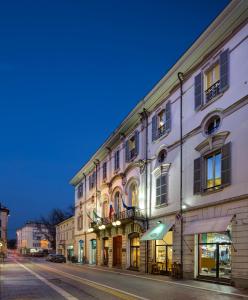 una fila di edifici su una strada di città di notte di Hotel Vittoria a Faenza