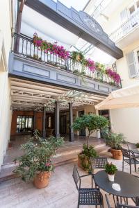 een patio met tafels en stoelen en een balkon met bloemen bij Casa Romagnosi in Salsomaggiore Terme