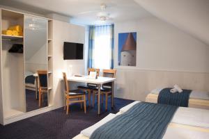 a hotel room with a bed and a desk and a bedroom at Pension Vicus in Passau