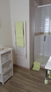 ein Bad mit einer Dusche und einem gelben Handtuch in der Unterkunft Les Nymphéas in Saint-Lyphard