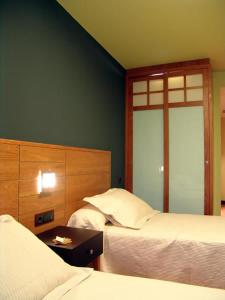 a bedroom with two beds and a table and a window at Buenavista in Cuenca