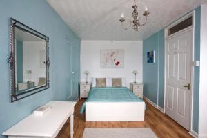 una camera da letto con un letto e uno specchio di The Old Farmhouse at Mena a Bodmin