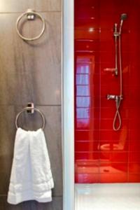 La salle de bains est pourvue d'une douche et d'une serviette blanche. dans l'établissement L'Olympique 1924, à La Garenne-Colombes