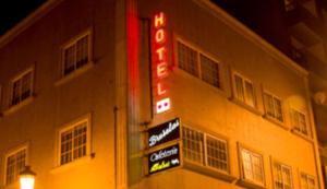 a hotel with neon signs on the side of a building at Hotel Bruselas in A Guarda