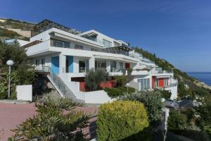 Un edificio blanco en una colina junto al océano. en Antiopi Luxury Villa, en Agia Pelagia