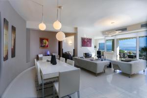 Una sala de estar con una mesa y sillas y un sofá. en Antiopi Luxury Villa, en Agia Pelagia