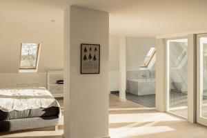 a white bedroom with a bed and a bathroom at Gutshaus Üselitz in Poseritz