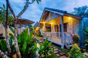 una casa con portico di notte di The Syron Huts Lembongan a Nusa Lembongan