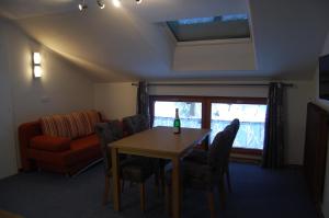 ein Wohnzimmer mit einem Tisch, Stühlen und einem Sofa in der Unterkunft Haus Waldrast in Elbigenalp