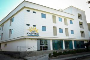 a large white building with a sign on it at Sol Caribe Hotel in Soledad