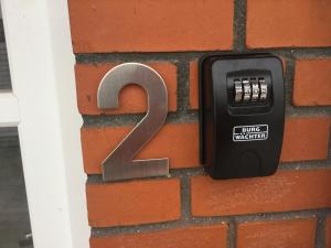 a mailbox with the number two on a brick wall at Billund Center Apartment in Billund