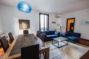 sala de estar con mesa y sofá azul en LuminHouse Mondello Zibibbo en Mondello
