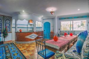 a living room with a table and a kitchen at Puerta Azul in Chefchaouen