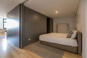 a bedroom with a large bed and a closet at Modern 18th Century Flat in Porto