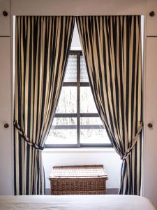 a window with striped curtains in a bedroom at Ericeira Sea View - Mar à Vista in Ericeira