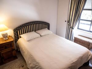 a bedroom with a white bed with a window at Ericeira Sea View - Mar à Vista in Ericeira