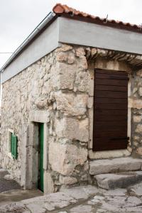 een stenen gebouw met een deur en een groene deur bij Solovi Dvori in Karlobag