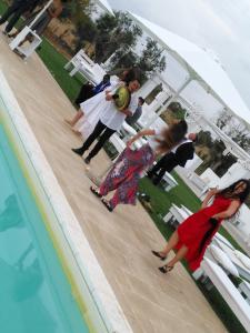 a group of people standing next to a swimming pool at Masseria Fulcignano in Galatone +182 photos