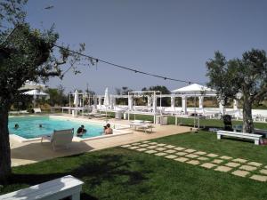 a swimming pool with people sitting in the water at Masseria Fulcignano in Galatone
