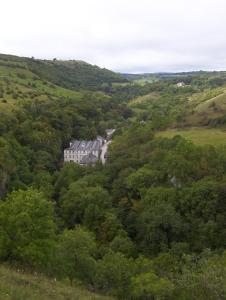 a building in the middle of a lush green forest at Litton Mill Apartment in Tideswell