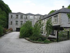 - un ancien bâtiment en pierre avec une allée devant dans l'établissement Litton Mill Apartment, à Tideswell