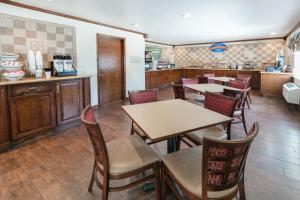 a restaurant with tables and chairs and a kitchen at Baymont by Wyndham Arlington At Six Flags Dr in Arlington