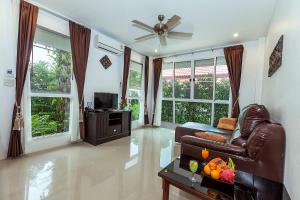 Una sala de estar con un sofá de cuero y un televisor. en Lux Family Villas Krabi Ao Nang, en Ao Nang Beach