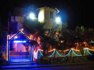 a house with christmas lights in front of a building at Tango Pension in Koycegiz